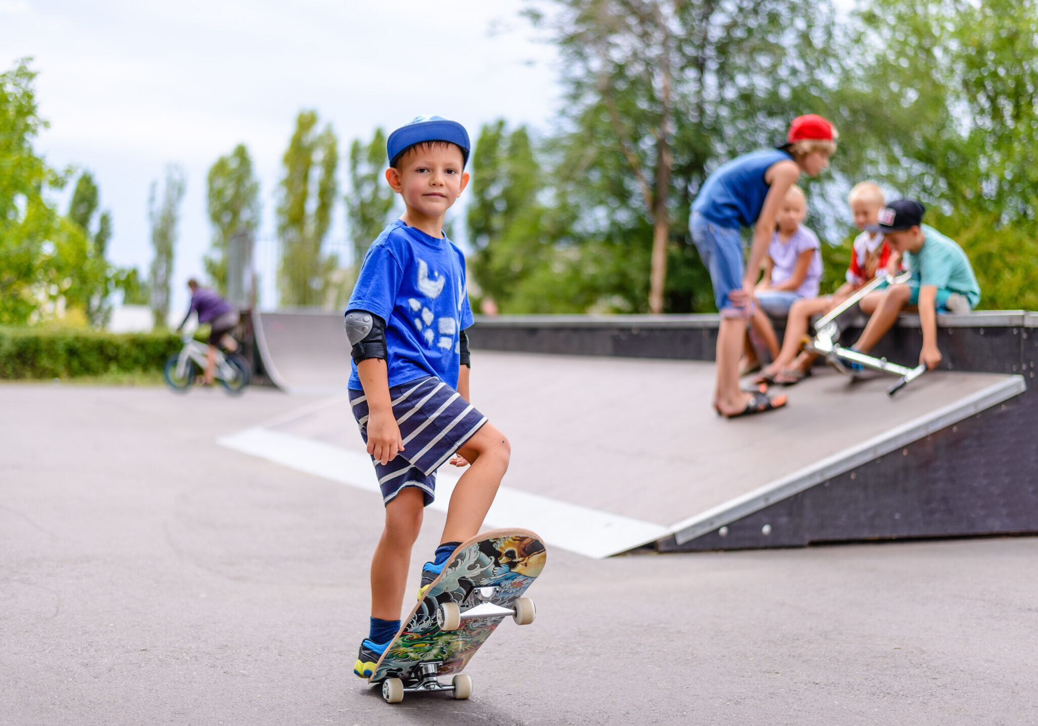 Young boy at a skate park with friends